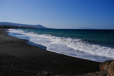 Santorini Yunan adasında kumlu bir sahilde dalgalar