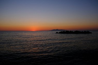 Sahilde denizden doğan güneşin görüntüsü