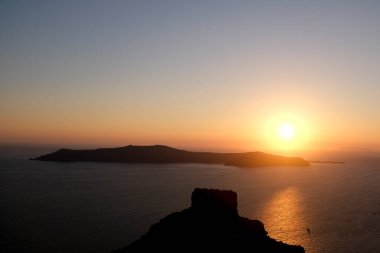 Yazın Santorini adasındaki Imerovigli köyünde kalderaya ve denize bakan günbatımı. Yunanistan. 