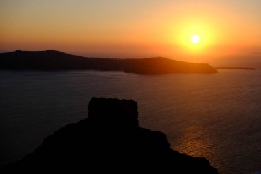 Yazın Santorini adasındaki Imerovigli köyünde kalderaya ve denize bakan günbatımı. Yunanistan. 