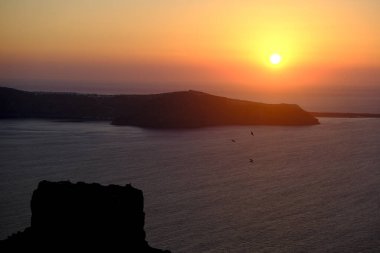 Yazın Santorini adasındaki Imerovigli köyünde kalderaya ve denize bakan günbatımı. Yunanistan. 