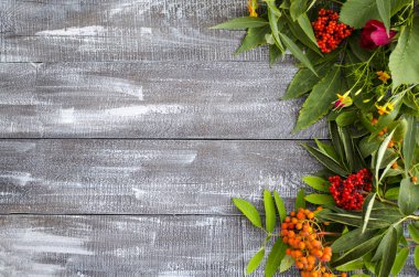 Çilek ve sonbahar yaprakları ahşap bir masada. Üst görünüm, kopya alanı ile sonbahar kavramı. Sonbahar çiçekleri ve çilek bir buket ile Ahşap arka plan.
