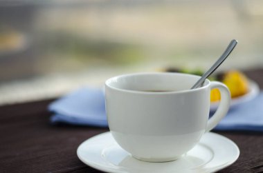 Çanak üzerinde yaban mersini ve bir toping olmadan üç cheesecakes, taze yaban mersini ve nane yaprakları ile süslenmiş vardır. Bir fincan kahve ile tekstil peçete kompozisyonu.