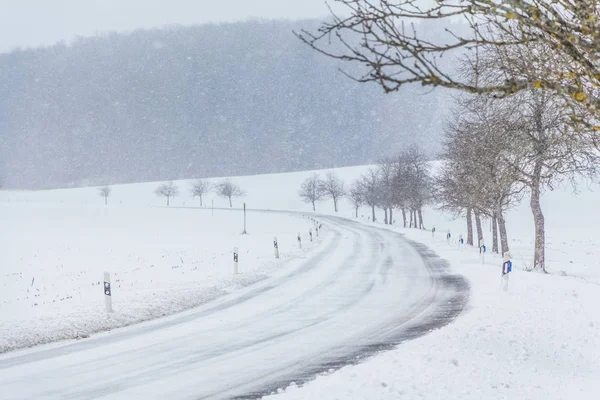 Trafik olmayan beyaz, karlı, buzlu kış yolu. — Stok fotoğraf
