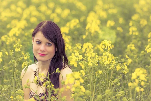 Souriant été amour femme assis dans le champ de colza heureux — Photo