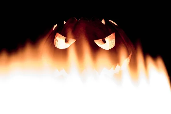 Carved spooky halloween pumpkin in hot burning hell fire flames