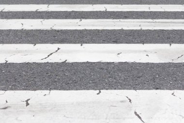Grey and white pedestrian crossing stripes on city downtown road