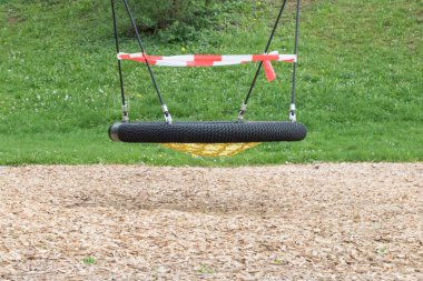 Corona virüsü karantina altına alınması çocuk parkı salınımlarını yasaklıyor. Bariyer bandıyla kapatma. Covid-19, salgın riski içeren güvenlik önleme eylemi. Kanun yönetmelikleriyle Coronavirus kısıtlaması