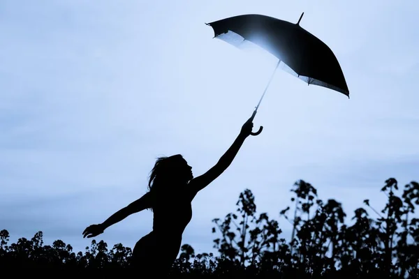 하늘까지 우산을 실루엣 비오는 자연의 소녀는 모험을 좋아하는 경향이 젊음의 — 스톡 사진