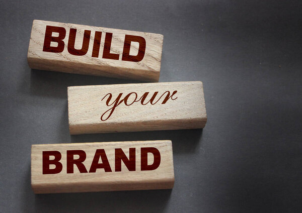Фраза BUILD YOUR BRAND написана на деревянных блоках. С винтажным стилем. Рекламная концепция ребрендинга.