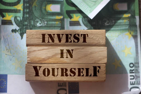 在100张欧元钞票上刻在木块上的短语 投资于你自己 软技能和成绩概念 个人储蓄和投资业务概念 — 图库照片