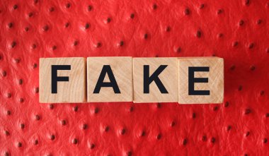 Kırmızı deri üzerine tahta bloklarla yazılmış sahte bir kelime. Sahte ya da gerçek haber, efsane ya da gerçek konsept.