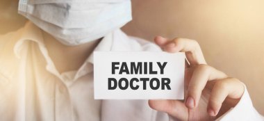 Yüz maskesi ve tıbbi giysi takan bir doktor üzerinde 