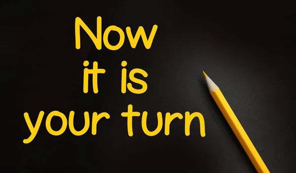 Now it is your turn words and yellow pencil on black background. Business Career concept.