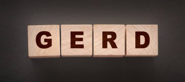 Kelime GERD gri bir arka planda ahşap yapı taşları ile yapılmış.