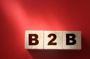 Kırmızı zemin üzerinde B2B kısaltması olan tahta küpleri ve kopyalama uzayı. İş konseptine