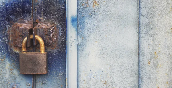 Old Lock hangs on a garage door with copyspace on the right. Locked content informational concept. Safe data concept.