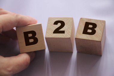 Tahta küplerdeki B2B kısaltması. Business to Busness konsepti Hand, B küpünü sıraya dizdi. İş pazarlama stratejisi kavramı.