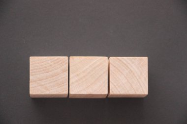 Koyu gri masa üzerinde kopyalama alanı olan tahta küp blok şekli.