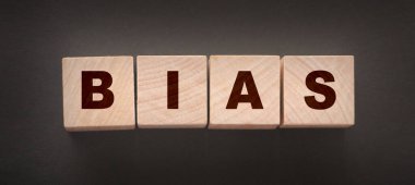 BIAS kelimesi, siyah bir arkaplan üzerinde ahşap harflerle yazılıyor..