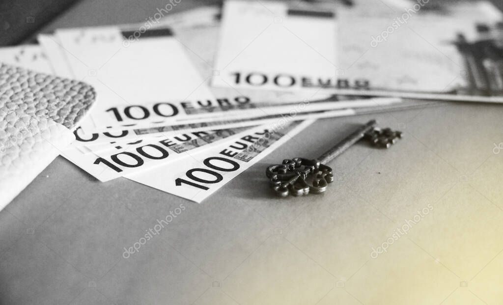 A key and 100 euro bills. Profitable Business success concept. Key to money concept. Black and white photo.