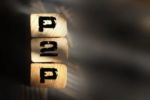 P2P kısaltması tahta bloklara yazılmış. Meslektaşlar arası iş kavramı. Ahşap alfabeyi.