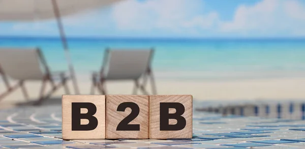 Business to Business concept. B2B letters on wooden cubes. Sunny beach and ocean background. Online business trading concept.