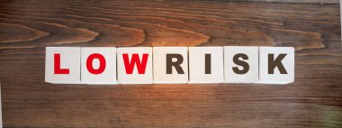 Tahta küplere yazılmış düşük riskli kelimeler. Mali risk değerlendirmesi, risk ödülü ve portföy risk yönetimi kavramı..