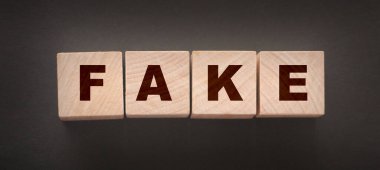 Siyah arkaplanda tahta bloklarla yazılmış sahte sözcük