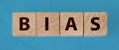 Tahta bloklar üzerinde önyargı kelimesi mavi arkaplan.