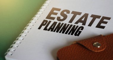 Fotokopi defteri sayfasında ve deri cüzdanda mülk planlama kelimeleri. Arazi veya bina satın almak için kullanılan emlak işletme konsepti.