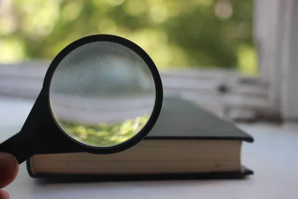 old book and magnifying glass. Search information, SEO, education and knowledge concept.