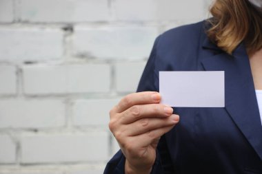 İş kadını boş bir kartvizit gösterip veriyor. Koyu mavi takım elbiseli bir iş kadını. İş konsepti