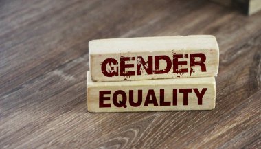 Ahşap arka planda uzun tahta bloklarda cinsiyet eşitliği kelimeleri. Eşitlik sosyal konsepti