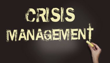 Kara tebeşirle yazılmış Kriz Yönetimi kelimesi. Tebeşirle yazılmış. Tahtada açık sarı yazı var. Risk yönetimi iş konsepti.