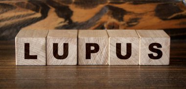 Lupus, tabletlerin ve termometrenin yanındaki mavi arkaplanda yazılı. İlaçlar. Yüksek kalite fotoğraf