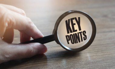 Ahşap masa üzerinde anahtar noktaları olan büyüteç.