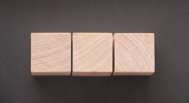 Koyu gri masa üzerinde kopyalama alanı olan tahta küp blok şekli.