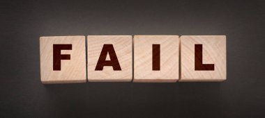 Başarısız Kelime metni siyah arkaplan üzerine tahta küp bloklarıyla yazılmış. İş krizi kavramı.