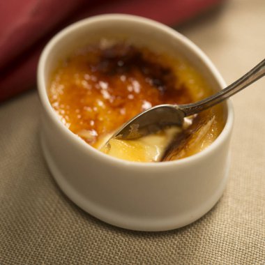Kasede kaşıkla taze krem brulee tatlı.