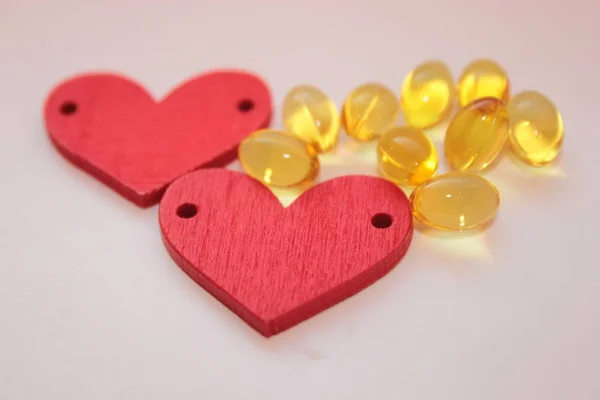 Dvě Dřevěná Srdce Hrstka Žlutých Tobolek — Stock fotografie