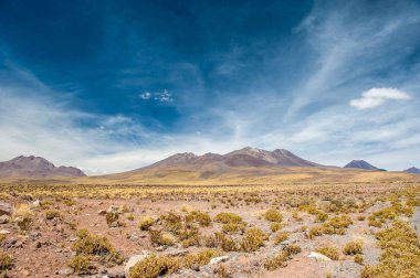 Atacama Çölü'nün volkanlarında parlak güneşli bir gün. Dağlar San Pedro de Atacama'nın güneyinde. Atacama çölünde parlak güneş ışığında çarpıcı manzara, Şili, Güney Amerika