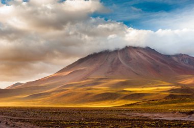 Atacama Çölü'ndeki volkanlarda gün batımı ışığı. Dağlar San Pedro de Atacama'nın güneyinde. Atacama çölünde akşam güneş ışığında çarpıcı manzara, Şili, Güney Amerika