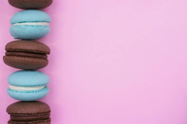 Makarnalı makarna kurabiyesi. Bisküvi, çikolata ve turkuaz renkler. Pembe arka planda kremalı pasta. Tatlı tatlı..