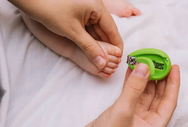 Nail clipping for a small child. Pedicure. Mom's little feet and hands. Hygiene for children.