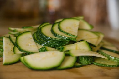 Yeşil kabak tahta bir tahtanın üzerinde daireler çiziyor. Kabak hasadı. Vejetaryen yemeği..