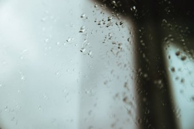 Pencerede yağmur damlaları. Güneş ışığı bardaktaki su damlacıklarından yansıyor. Arkaplan ve doku.