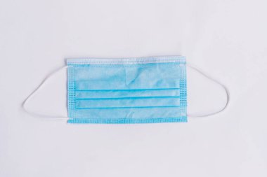 Beyaz arka planda mavi tıbbi maske. Kişisel koruyucu ekipman. Koruyucu maske.