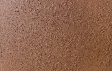 Dekoratif macun. Duvar kahverengi. Net olmayan bir doku. Macunun arkaplanı.