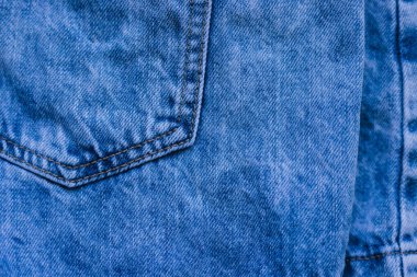 Kot pantolonun ayrıntıları. Cepleri ve dikişleri denim üzerinde. Eski mavi denim. Kot kumaşının dokusunda. Arkaplan.